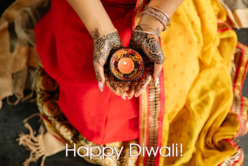 Lotus Market - Happy Diwali - Hands with a Diwali candle and text.